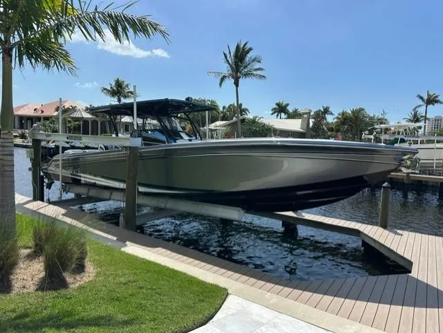 Slide: The Image of 2024 Nor-Tech 390 Sport boat docked by waterfront with palm trees. - 10