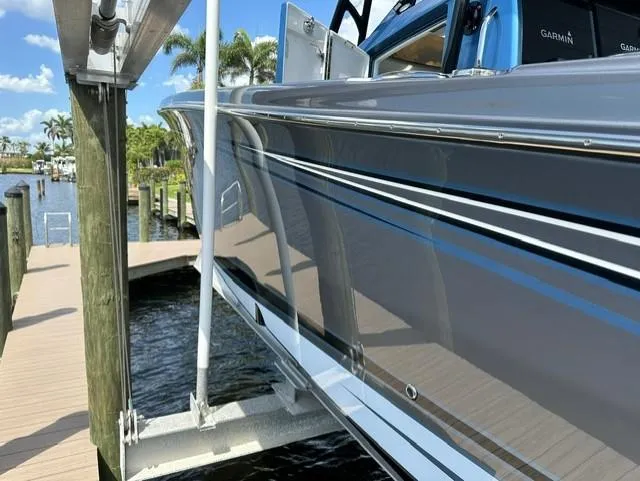 Slide: The Image of 2024 Nor-Tech 390 Sport boat docked, showcasing sleek gray and blue design. - 12