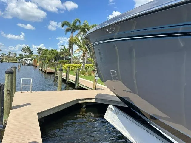 Slide: The Image of 2024 Nor-Tech 390 Sport boat docked by a sunny waterfront with palm trees. - 15