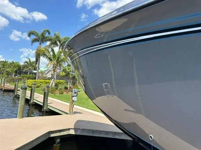 Slide: The Image of 2024 Nor-Tech 390 Sport boat docked by palm trees under a clear blue sky. - 16