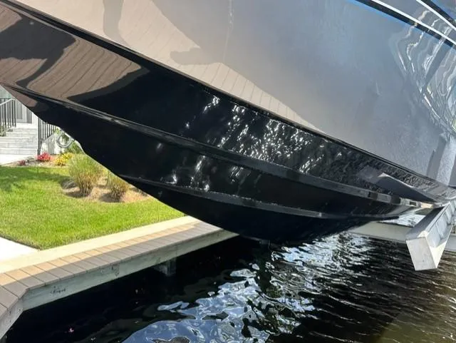 Slide: The Image of 2024 Nor-Tech 390 Sport boat hull above water near dock. - 17