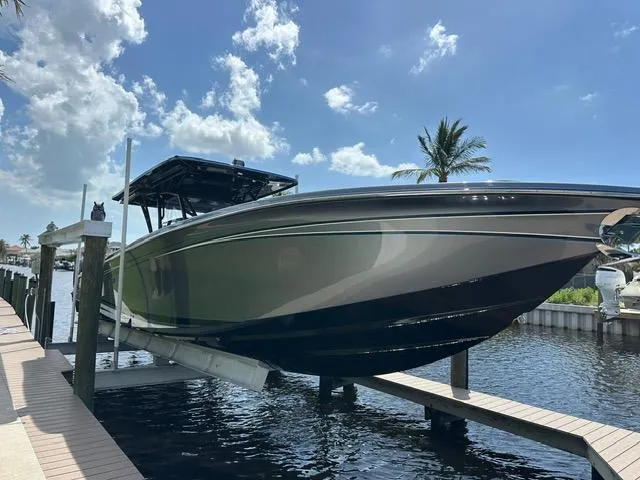 Slide: The Image of 2024 Nor-Tech 390 Sport boat docked under a clear blue sky. - 2