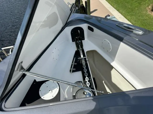 Slide: The Image of 2024 Nor-Tech 390 Sport anchor compartment, open hatch, showcasing chain and mechanism. - 32