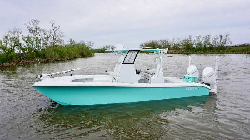Slide: The Image of 2022 Costa Custom Boats 264 HC in water, side view, light blue hull, calm surroundings. - 2