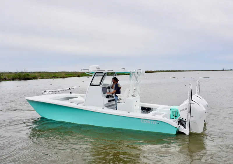 Slide: The Image of 2022 Costa Custom Boats 264 HC on water, side view, with person at helm. - 5