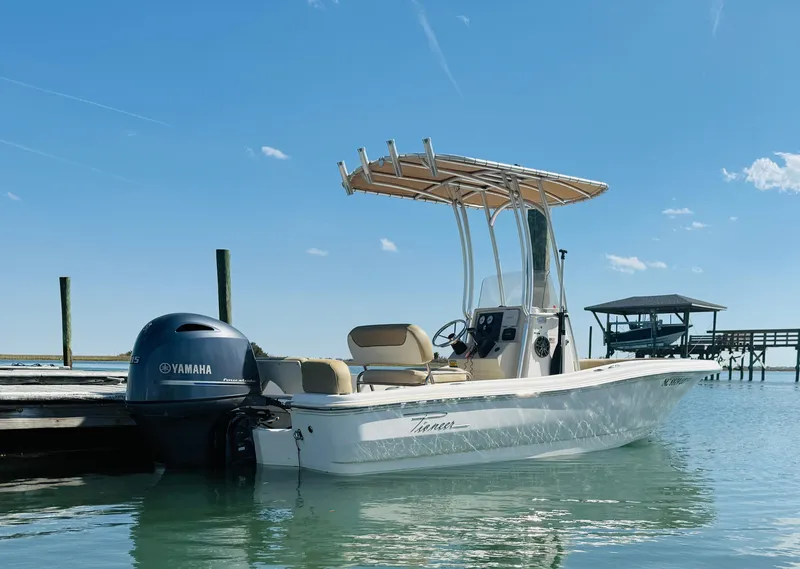 Slide: The Image of 2015 Pioneer 180 Islander boat docked, featuring Yamaha outboard motor, under clear blue sky. - 4
