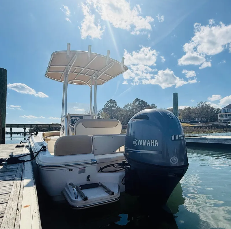 Slide: The Image of 2015 Pioneer 180 Islander boat docked with Yamaha 115 engine under sunny sky. - 6