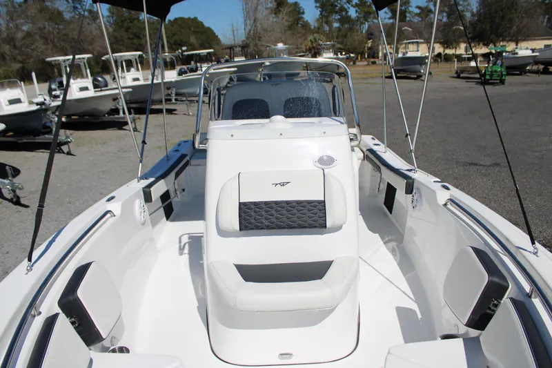 Slide: The Image of 2025 Tidewater 198 CC Adventure boat interior with seating and console, parked outdoors. - 11