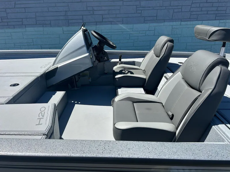 Slide: The Image of 2025 Express H20 Bass boat interior with gray seating and steering console. - 7
