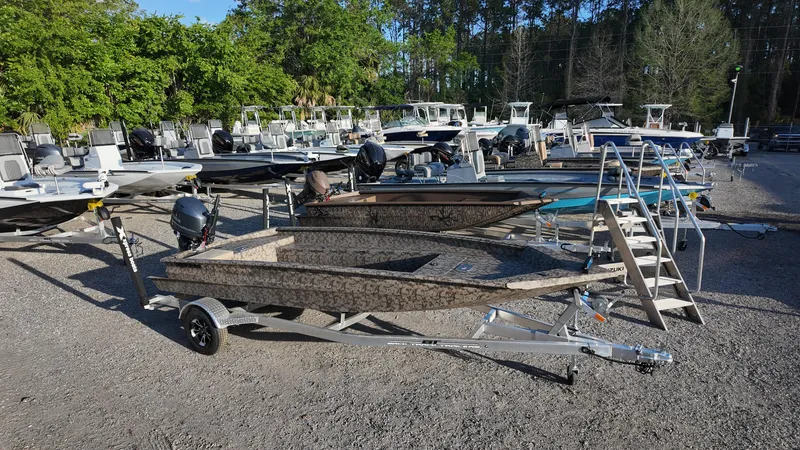 Slide: The Image of 2025 Xpress H18DB boat on trailer in outdoor showroom with multiple boats. - 11