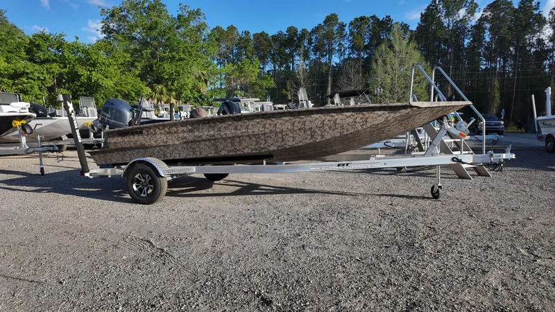 Slide: The Image of 2025 Xpress H18DB boat on trailer in outdoor setting with trees. - 13