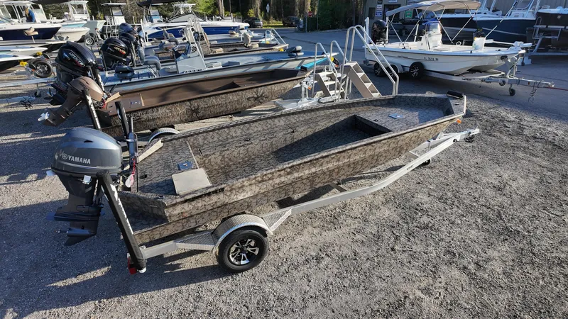 Slide: The Image of 2025 Xpress H18DB boat on trailer, parked in a marina with other boats. - 14