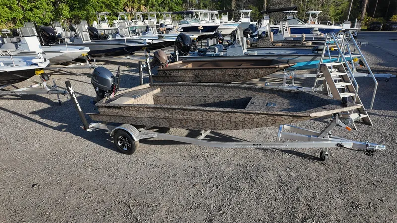 Slide: The Image of 2025 Xpress H18DB boat on trailer in outdoor showroom. - 2