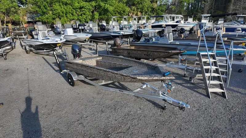 Slide: The Image of 2025 Xpress H18DB boat on trailer in a marina with multiple boats. - 6