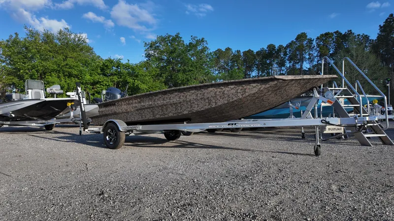 Slide: The Image of 2025 Xpress H18DB boat on trailer, parked outdoors under a clear blue sky. - 8