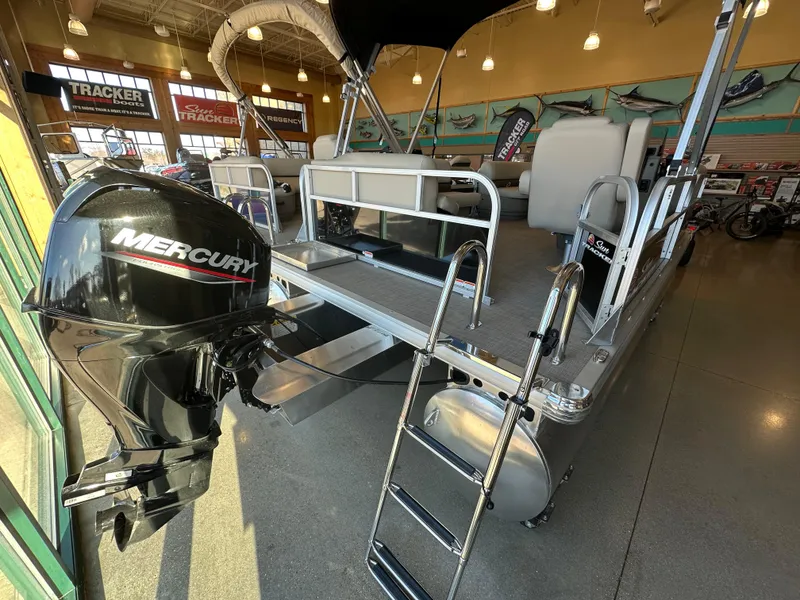 Slide: The Image of 2025 Sun Tracker Party Barge 16 DLX pontoon boat with Mercury outboard motor in showroom. - 5