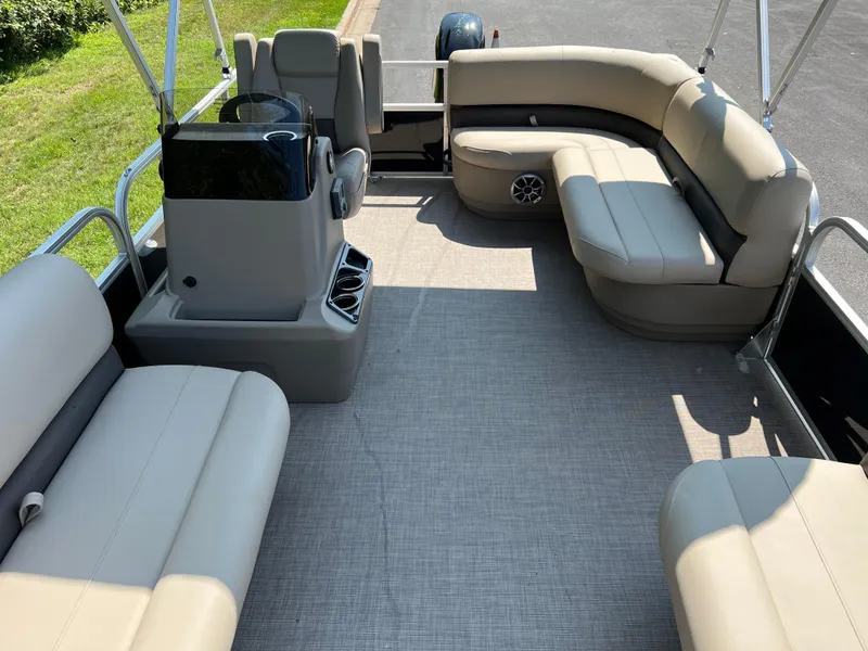 Slide: The Image of 2025 Sun Tracker Party Barge 16 DLX interior with beige seating and helm station. - 6
