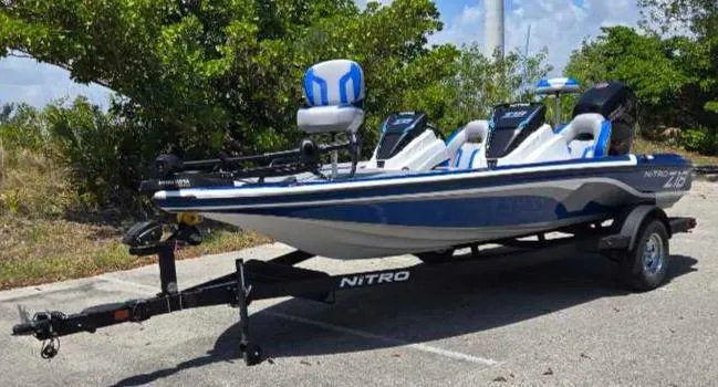Slide: The Image of 2025 Nitro Z18 boat on trailer, parked outdoors, featuring blue and white design. - 2