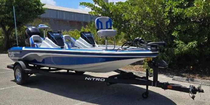 Slide: The Image of 2025 Nitro Z18 boat on trailer, parked outdoors, surrounded by greenery. - 4
