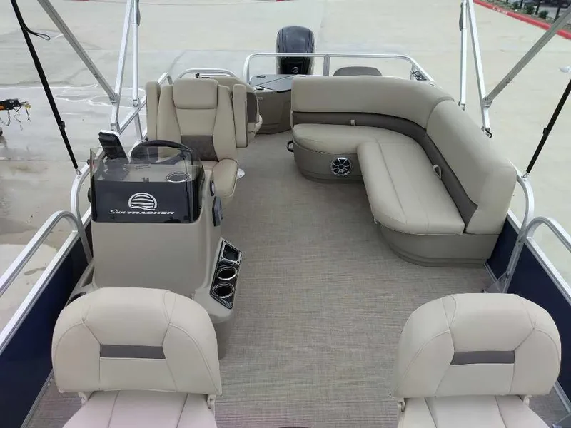 Slide: The Image of 2025 Sun Tracker Bass Buggy 18 DLX pontoon boat interior with beige seating and helm. - 4