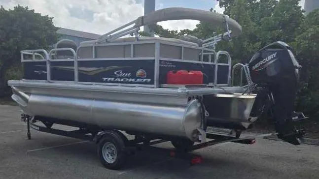 Slide: The Image of 2025 Sun Tracker Bass Buggy 16 XL Select pontoon boat on trailer. - 2