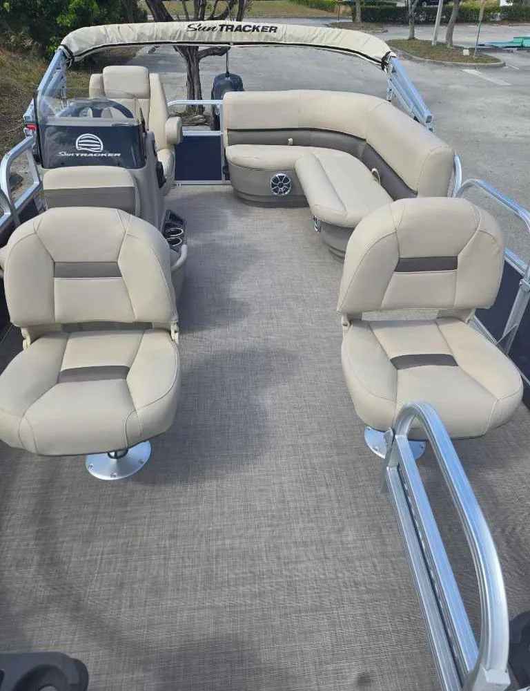 Slide: The Image of 2025 Sun Tracker Bass Buggy 16 XL Select pontoon boat with beige seating and spacious layout. - 5