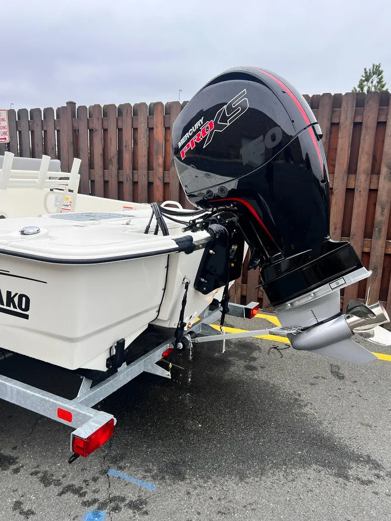 Slide: The Image of 2025 Mako Pro Skiff 19 CC boat with powerful outboard motor, parked on a trailer. - 1