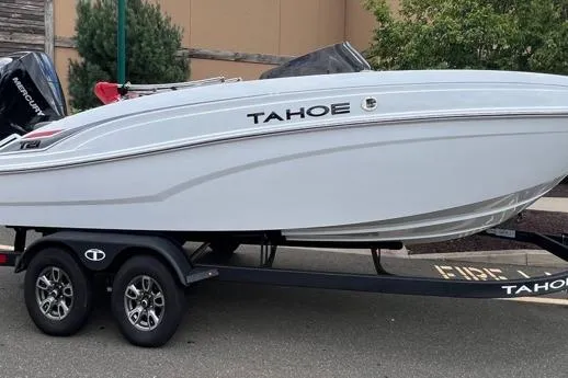 The Image of 2025 Tahoe T21 boat on trailer, sleek design, parked outdoors. - 0