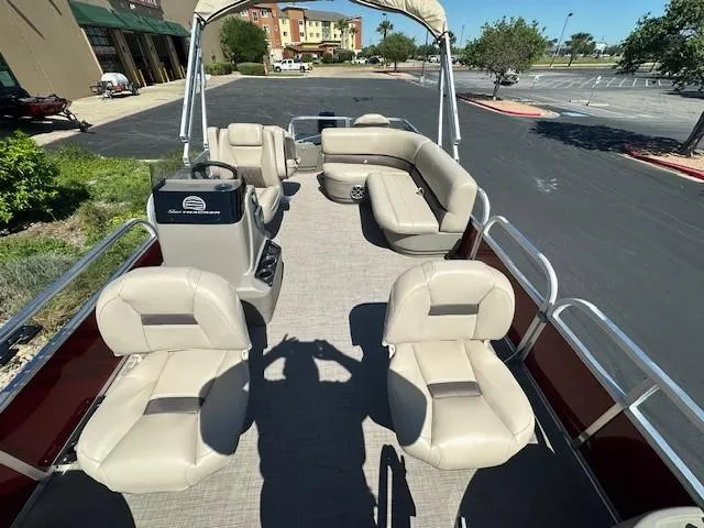 Slide: The Image of 2025 Sun Tracker Bass Buggy 18 DLX pontoon boat with beige seating and canopy. - 2