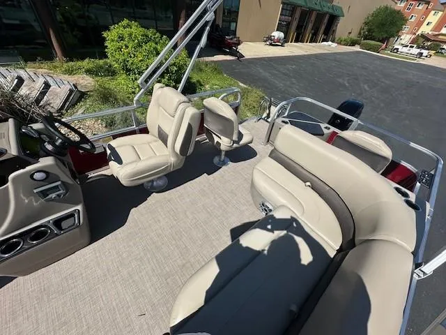Slide: The Image of 2025 Sun Tracker Bass Buggy 18 DLX pontoon boat interior with beige seating and steering console. - 3