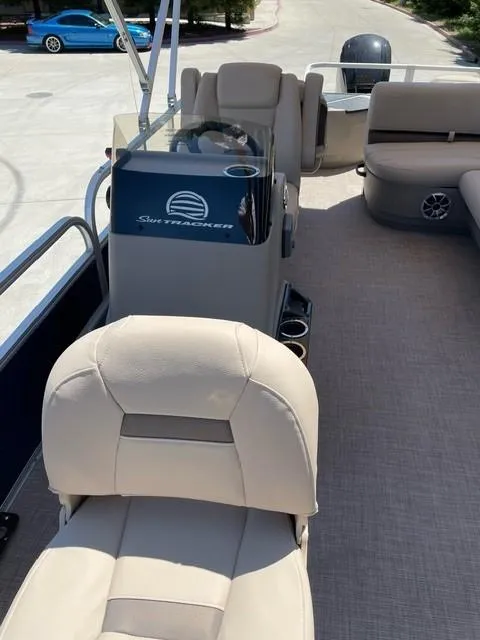 Slide: The Image of 2025 Sun Tracker Bass Buggy 18 DLX interior with beige seating and steering console. - 3