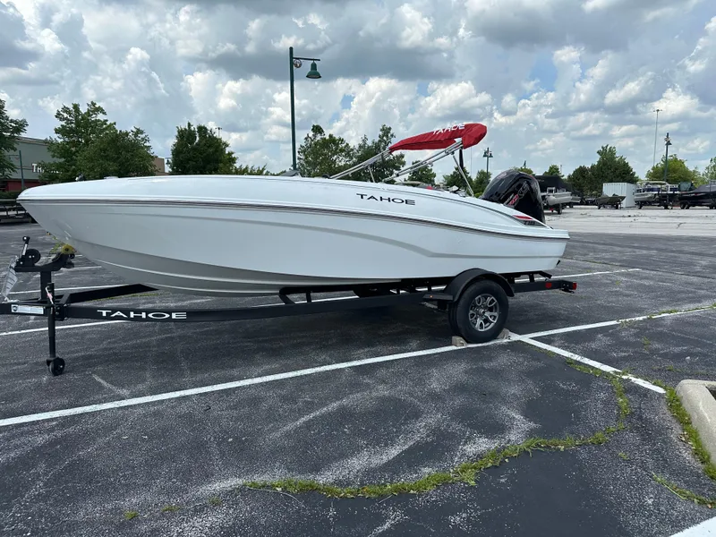 Slide: The Image of 2025 Tahoe T18 boat on trailer in parking lot under cloudy sky. - 2