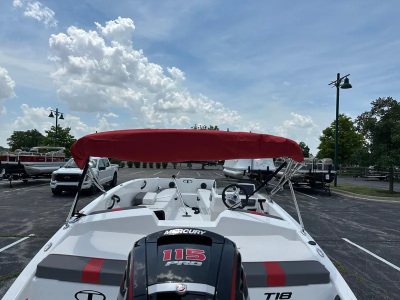 Slide: The Image of 2025 Tahoe T18 boat with red canopy and Mercury 115 Pro motor in parking lot. - 3