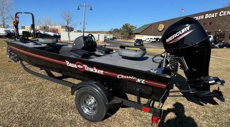 Slide: The Image of 2025 Tracker Bass Tracker Classic XL boat with Mercury engine on grassy area. - 3