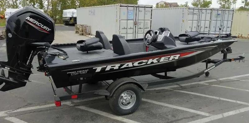 Slide: The Image of 2025 Tracker Pro Team 175 Crappie Edition boat with Mercury engine in parking lot. - 2