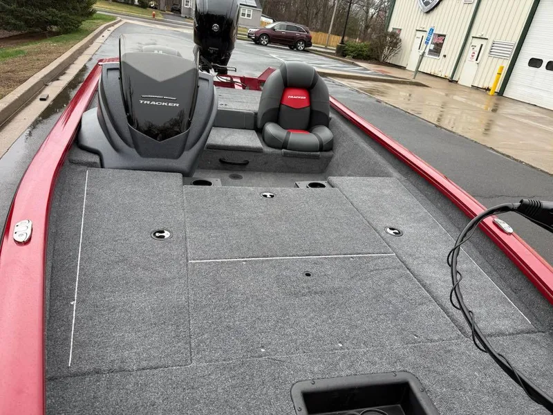 Slide: The Image of 2025 Tracker Pro Team 175 boat with red and gray interior, parked outdoors. - 3