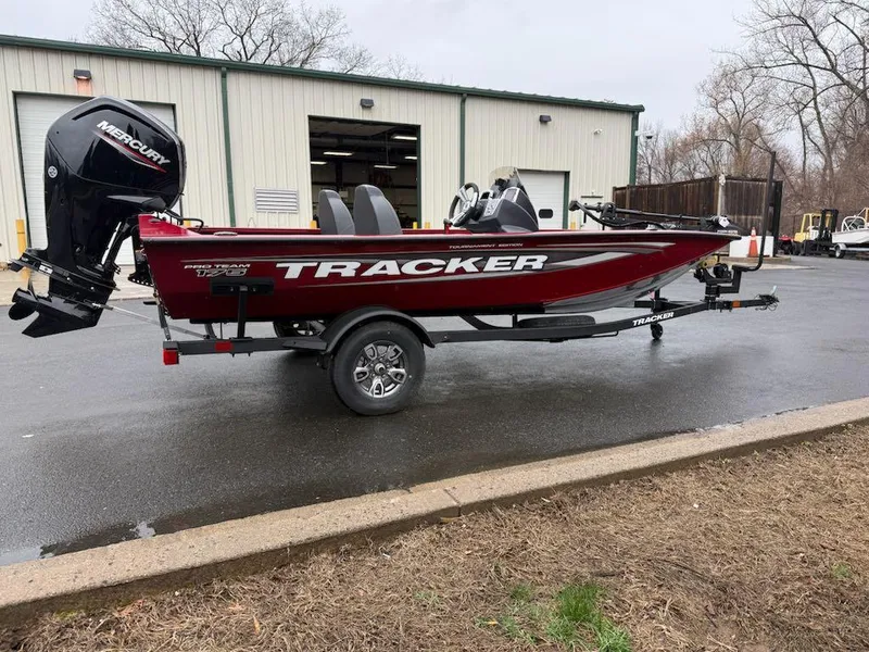 Slide: The Image of 2025 Tracker Pro Team 175 boat on trailer, parked outside a warehouse. - 4