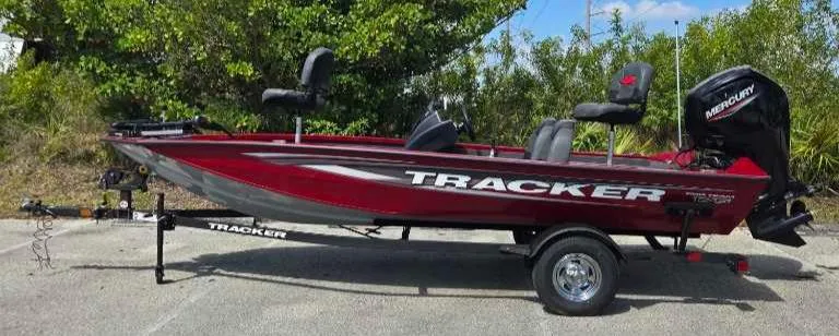The Image of 2025 Tracker Pro Team 175 boat on trailer, red color, parked outdoors. - 0