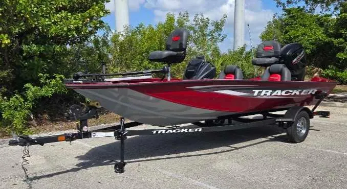 Slide: The Image of 2025 Tracker Pro Team 175 boat, red and gray, parked on a trailer. - 2