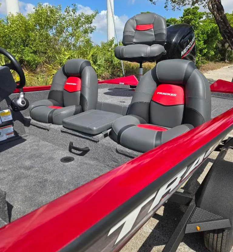 Slide: The Image of 2025 Tracker Pro Team 175 boat with red and gray seating, outdoors. - 8