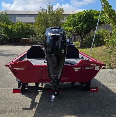 Slide: The Image of 2025 Tracker Pro Team 175 boat, red exterior, parked outdoors, rear view. - 9