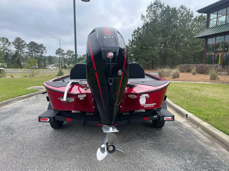 Slide: The Image of 2025 Tracker Savage 215 boat with powerful outboard motor, parked outdoors. - 4
