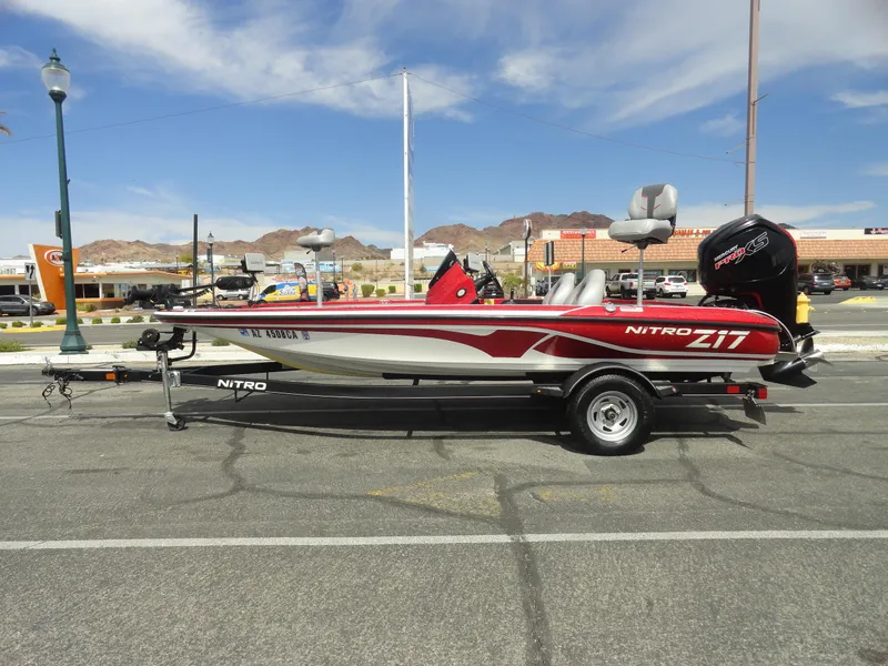 Slide: The Image of 2018 Nitro Z17 boat on trailer, parked in urban area with mountains in background. - 1