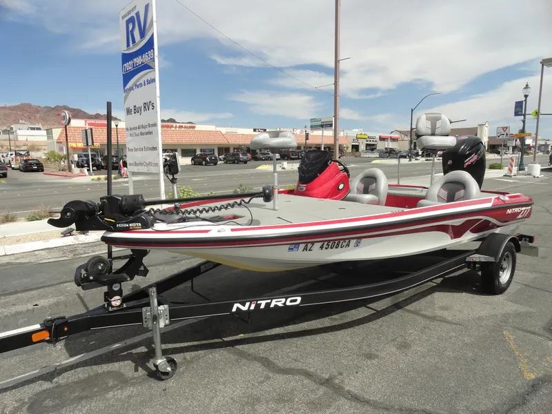 Slide: The Image of 2018 Nitro Z17 boat on trailer in parking lot, with RV dealership in background. - 2
