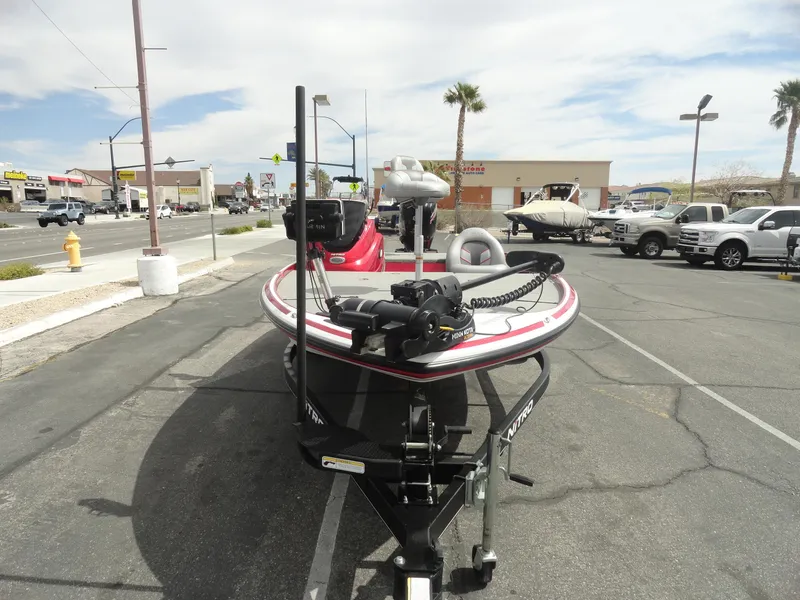 Slide: The Image of 2018 Nitro Z17 boat on trailer in parking lot, surrounded by vehicles and palm trees. - 3