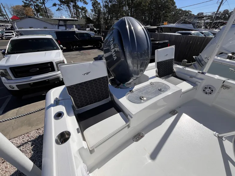 Slide: The Image of 2025 Tidewater 2110 Bay Max boat interior with seating and motor, parked outdoors. - 4