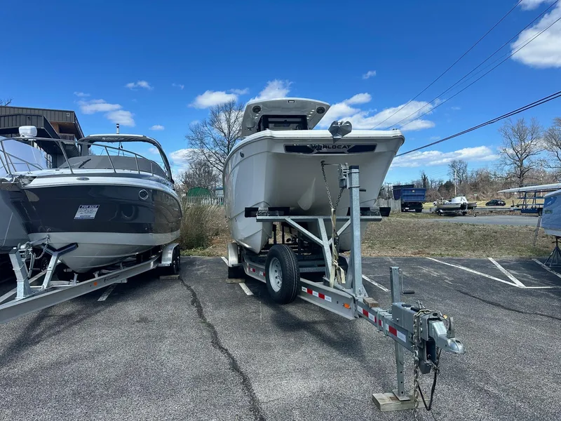 Slide: The Image of 2023 World Cat 260 CC-X boat on trailer in parking lot under blue sky. - 2