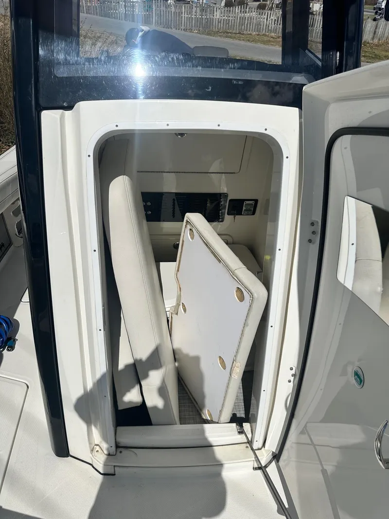 Slide: The Image of 2023 World Cat 260 CC-X boat interior storage compartment with open door. - 28