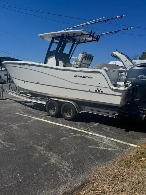Slide: The Image of 2023 World Cat 260 CC-X boat on trailer, parked outdoors under clear blue sky. - 8