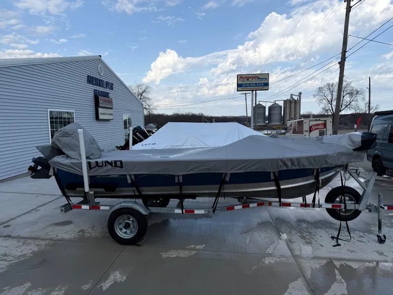 Slide: The Image of 2021 Lund 1600 Fury Tiller boat covered on a trailer outside a dealership. - 25
